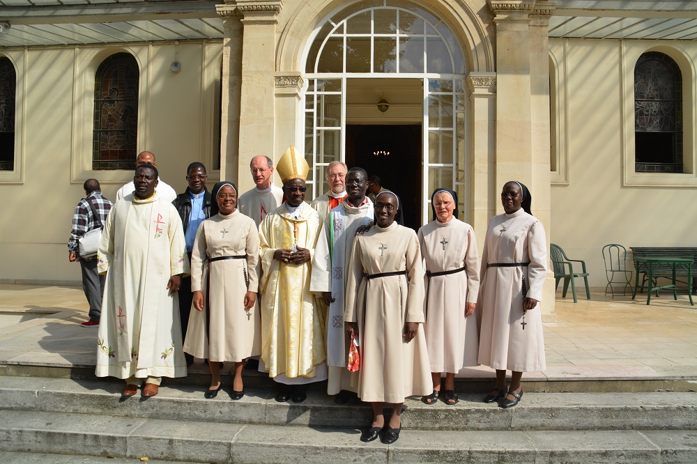 Monseigneur Sarr, entourée des deux nouvelles professes, de la supérieure générale, de la maîtresse des novices, et des prêtres ayant participé à la cérémonie