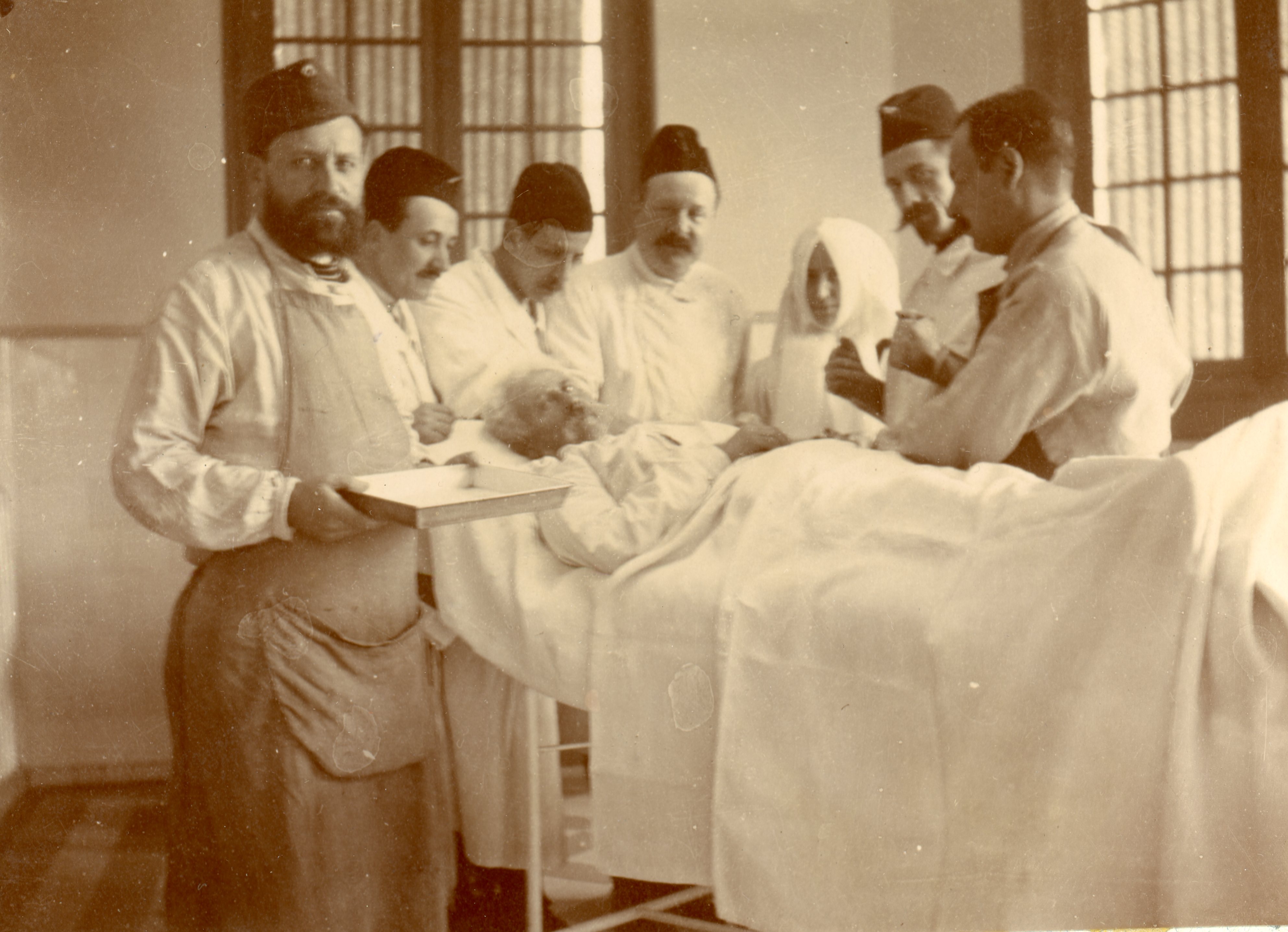 Religieuse auprès d'un blessé, entourée d'infirmiers