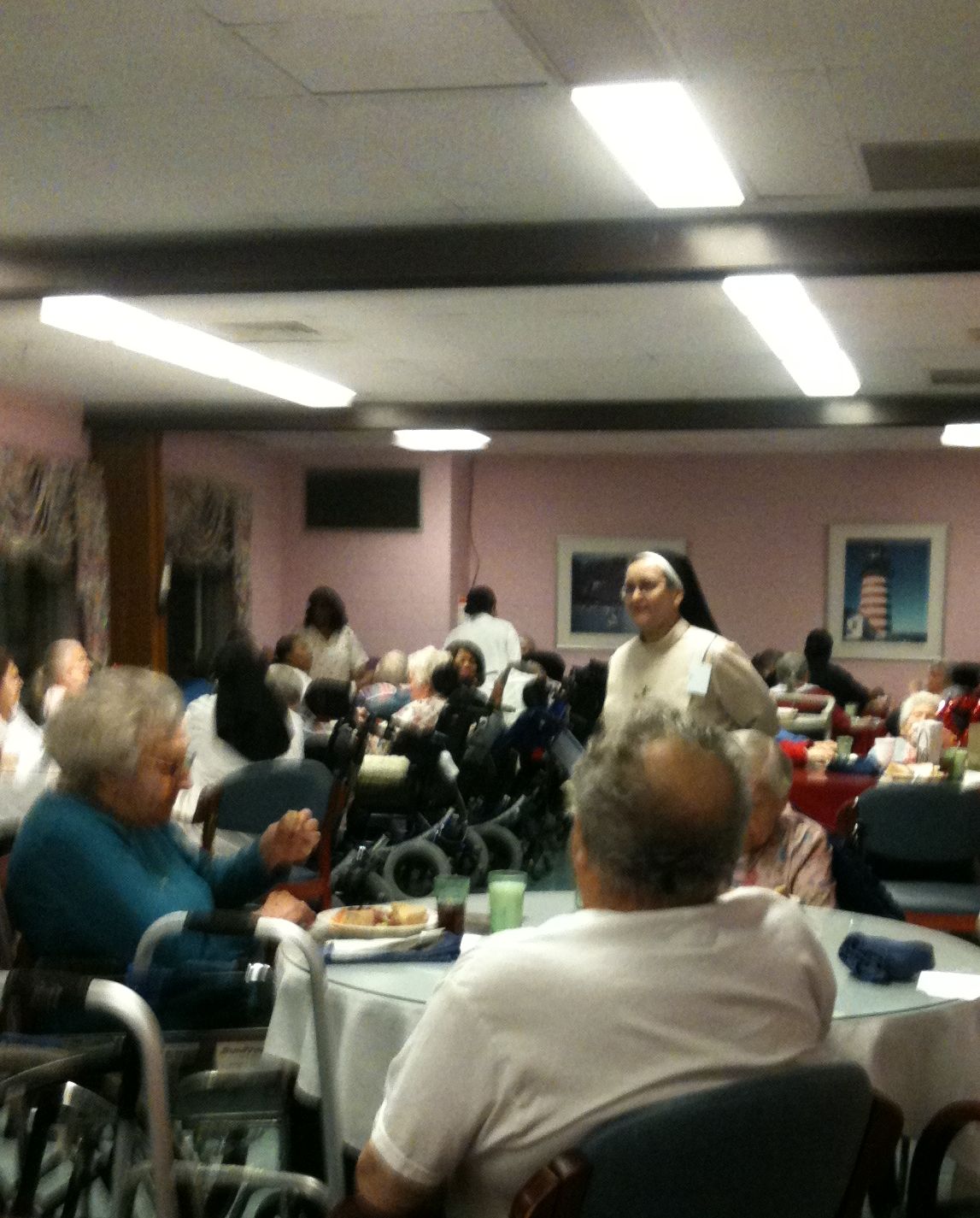 Religieuse parmi les patients dans la salle à manger