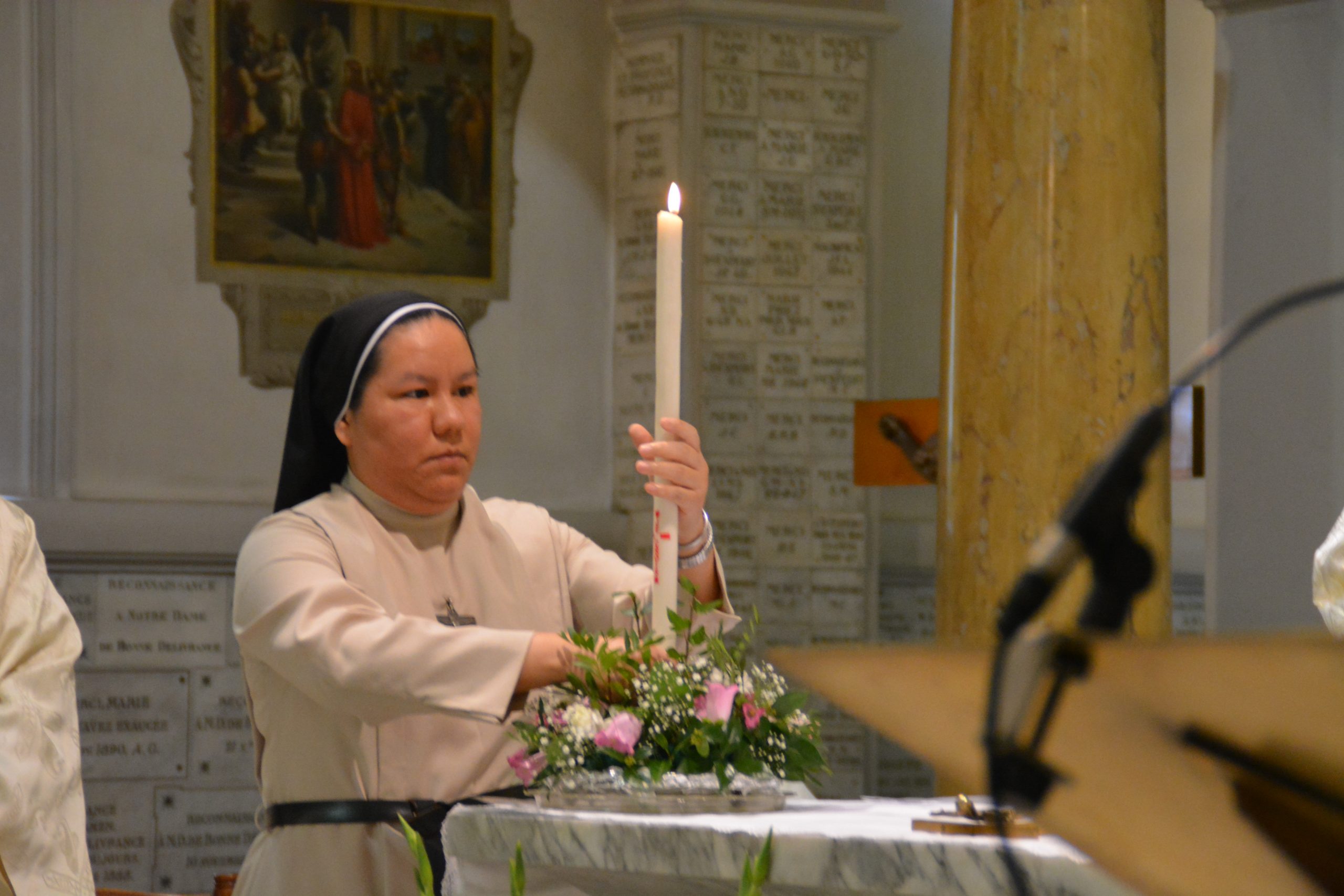 Soeur Véronica dépose son cierge sur l'autel